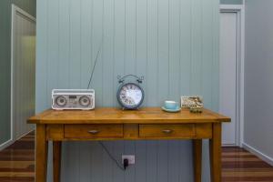 a table with a clock and a radio on it at Debs Shed in Arcadia