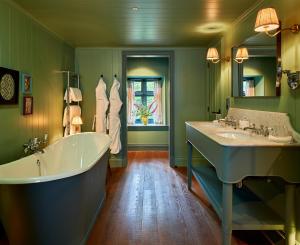 a green bathroom with two sinks and a tub at Penmaenuchaf Hotel in Dolgellau +46 photos