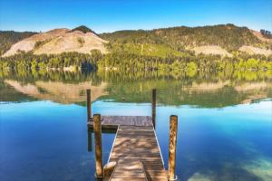 a dock on a lake with mountains in the background at A-Frame Cabin Dock Access & Views BBQ in Hoodsport