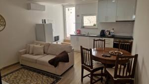 a living room and kitchen with a couch and a table at Casa do Arco in Aljubarrota
