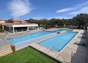 a large swimming pool with a deck and a building at TRA MANNA in Lecci