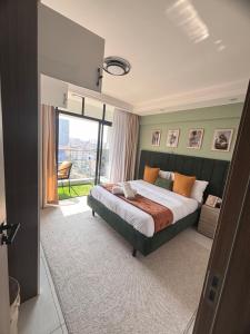 a bedroom with a large bed and a large window at Serenity Spot - Cozy 1 bedroom with AC and Heater with City View in Nairobi, Westlands in Nairobi