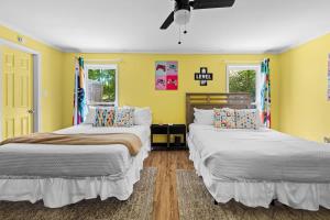 two beds in a room with yellow walls at 2 Bed 1 Bath Private Suite Funky Bunch TYSUT in Louisville