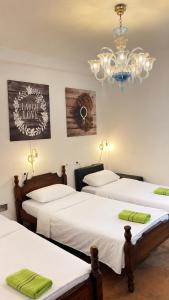 a room with three beds and a chandelier at Hostel Backpacker in Ulcinj