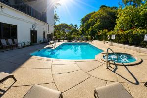 a swimming pool with chairs and a table at Hawaiian Princess Beachfront 1BR in Waianae
