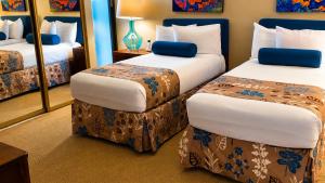 a hotel room with two beds and a mirror at Hawaiian Princess Beachfront 1BR in Waianae +12 photos