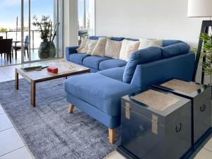 a blue couch and a coffee table in a living room at Blue on Blue Apartment 933 in Nelly Bay