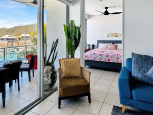 a living room with a blue chair and a bedroom at Blue on Blue Apartment 933 in Nelly Bay