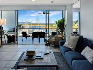 a living room with a blue couch and a table at Blue on Blue Apartment 933 in Nelly Bay +15 photos