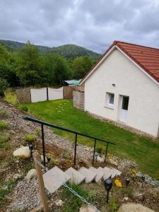 a house with a fence in front of a yard at La cabane de rose in Fresse-sur-Moselle
