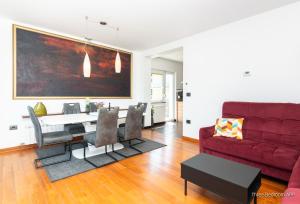 a living room with a red couch and a table at Residence Almarea by Locap Group in Izola