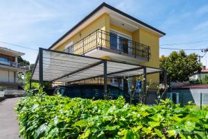 a yellow house with a balcony and bushes at Residence Almarea by Locap Group in Izola