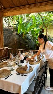 a woman standing in front of a table with glasses at Röstiland by NOXAMA SAMUI in Lamai