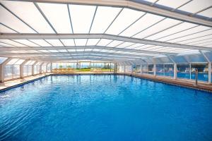 ein großes Schwimmbecken mit einer Decke aus blauem Wasser in der Unterkunft Hotel Servigroup Marina Playa in Mojácar