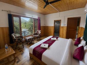 a bedroom with a large bed and a table and chairs at Sneha Riverside Cottage, Tirthan Valley - Best selling cottage in Jibhi 2025-26 in Jibhi +51 photos