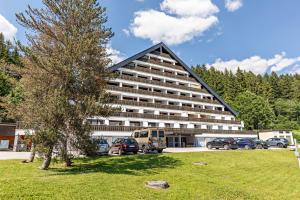 a large building with cars parked in a parking lot at Grimmingblick Apartment mit Pool in Reith