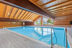 a swimming pool in a house with a wooden ceiling at Grimmingblick Apartment mit Pool in Reith