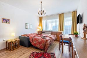 a bedroom with a bed and a desk and a table at Grimmingblick Apartment mit Pool in Reith