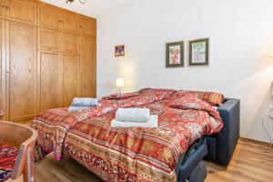 a bedroom with a bed with a blanket on it at Grimmingblick Apartment mit Pool in Reith +19 photos