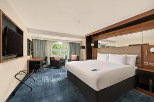 a hotel room with a large bed and a desk at Crowne Plaza Gerrards Cross by IHG in Beaconsfield