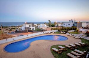 a view of a swimming pool with lounge chairs and the ocean at Hotel Maritur - Adults Only by Pierre & Vacances in Albufeira