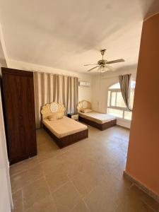a living room with two beds and a ceiling fan at Luxury Duplex Villa for Rent in Dawwār Muḩammad Abū Shanab