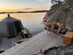 a dock with two chairs and a tent on the water at Stockholm Archipelago Igloo Hut in Tynningö