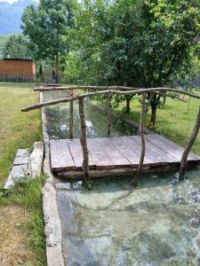 a wooden bridge in a body of water at Blue Eye in Vusanje +2 photos