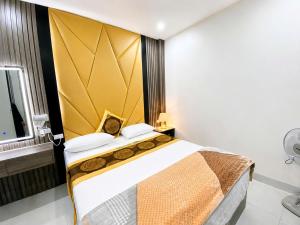 a bedroom with a large bed with a yellow headboard at Nhà Nghỉ Lacasta Hotel in Văn La