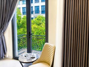 a room with a large window with a table and chairs at Nhà Nghỉ Lacasta Hotel in Văn La