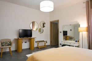 a bedroom with a bed and a tv and a mirror at Cozy guest house Downtown in Olbia