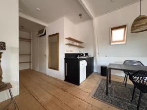 a living room with a table and a kitchen at Logement Hoogend in Sneek