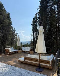a patio with couches and an umbrella on a deck at Villa Fioriamo in Greve in Chianti