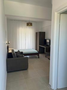 a living room with a couch and a bed at Paliovarka Rooms in Mitika