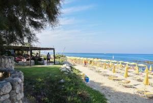 カーポ・ヴァチカーノにあるBaia Del Sole Resortの浜辺の椅子・傘