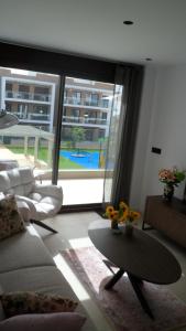 a living room with a couch and a table and a large window at Villa Ceesito in Los Alcázares