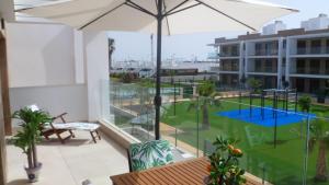 a balcony with an umbrella and a pool at Villa Ceesito in Los Alcázares