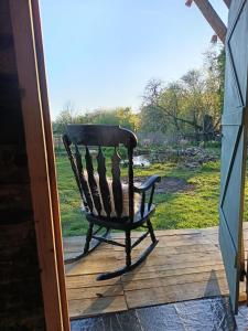 a wooden bench sitting on a porch at Le CLOS SUZANNE in Vesaignes-sous-Lafauche