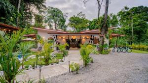 a house with a garden with bikes parked in front of it at Casa AMALFI Pool House Playa Neg in Puerto Viejo
