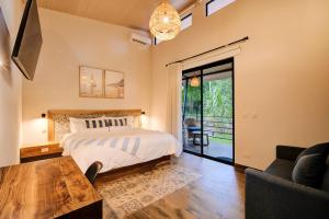 a bedroom with a bed and a table at Casa AMALFI Pool House Playa Neg in Puerto Viejo +37 photos