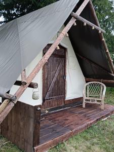 a yurt with a chair and a door at Le CLOS SUZANNE in Vesaignes-sous-Lafauche