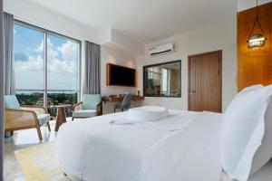 a white bedroom with a large white bed and a living room at Abantu Hotel in Dar es Salaam +30 photos