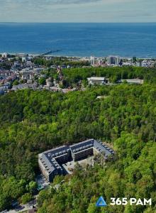 an overhead view of a building on a hill next to the ocean at 365PAM - Apartament Sea & Forest - BASEN KRYTY I ZEWNĘTRZNY, JACUZZI, SAUNA, GARAŻ W CENIE in Międzyzdroje +54 photos