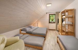 a room with two beds and a book shelf at Apartmany Izbica in Červený Kláštor