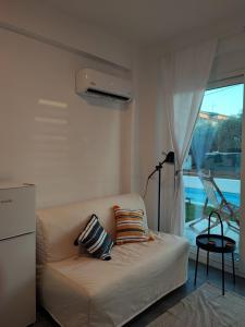 a white couch in a living room with a window at Blue view in Skala Rachoniou