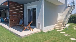 a house with a staircase and a chair next to a door at Blue view in Skala Rachoniou