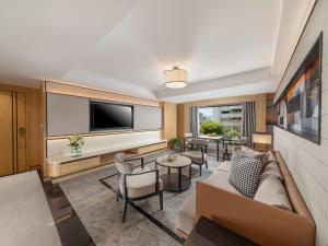 a living room with a couch and a tv at Samala Suites Bangkok Sukhumvit 19 by Kingston Hotels in Bangkok