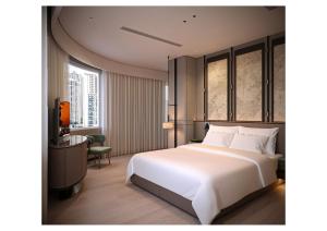 a bedroom with a large white bed and a desk at DUHORÉA Hotel and Wellness in Hanoi