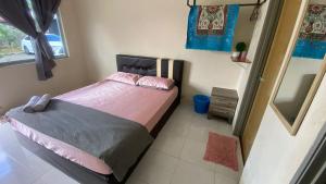 a small bedroom with a bed and a mirror at Hotel O D Mama Chalet in Jeniang