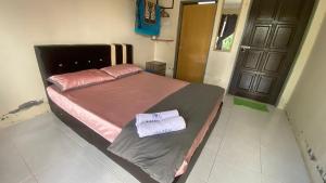 a bedroom with a bed with two towels on it at Hotel O D Mama Chalet in Jeniang
